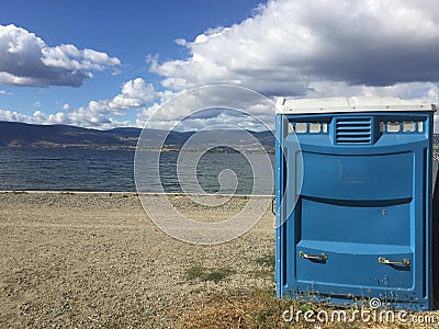 Blue port a potty on lake shore Stock Photo