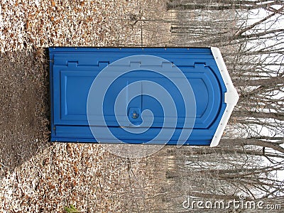 Blue Porta Potty in a woods Stock Photo