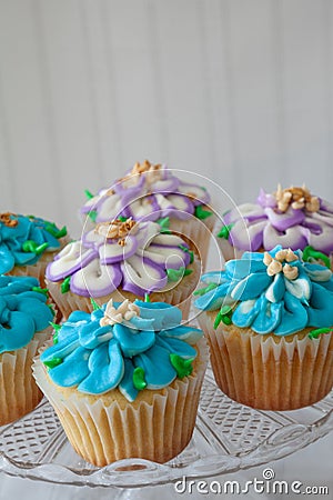 Blue and Purple frosted cupcakes decorated with gold dust Stock Photo