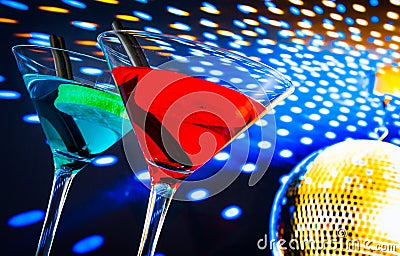 Blue and red cocktail with golden sparkling disco ball background with space for text Stock Photo