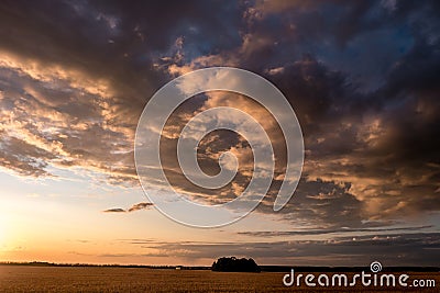 Blue red sky background with evening fluffy curly rolling clouds with setting sun. Good windy weather Stock Photo