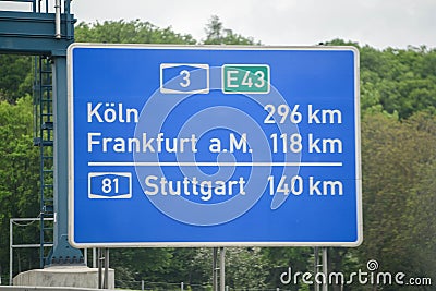 Blue road sign between Cologne, Frankfurt am Main and Stuttgart Editorial Stock Photo