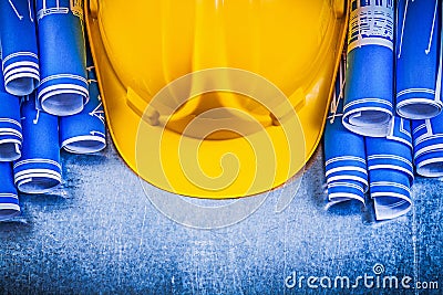 Blue rolled engineering drawings yellow building helmet on metal Stock Photo