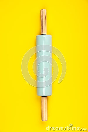 Blue rolling pin on yellow background, flat lay Stock Photo