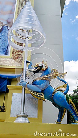 Blue royal lion holding tiered umbrella Stock Photo