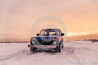 Blue Russian off-road car Lada Niva 4x4 VAZ 2121/21214 parked on the snow field. Editorial Stock Photo