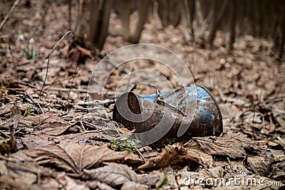 A blue rusty can with paint that was thrown away in an autumn forest Stock Photo