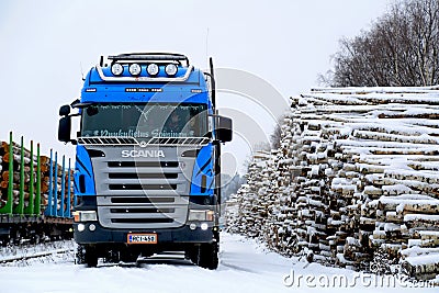 Blue Scania V8 Logging Truck at Snowy Railway Timber Yard Editorial Stock Photo