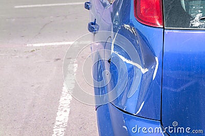 Blue scratched car with damaged paint in crash accident or parking lot and dented damage of metal body from collision Stock Photo