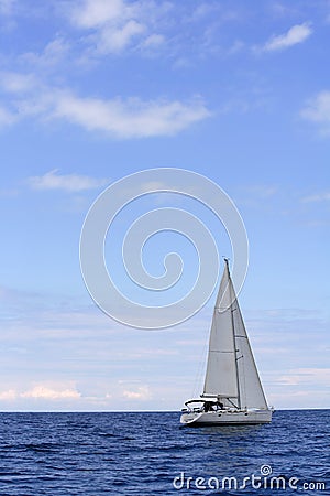 Blue sea with sailboat sailing the ocean Stock Photo