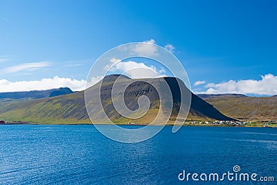 Blue sea water on mountain landscape in isafjordur, iceland. Hilly coastline on sunny blue sky. Summer vacation on Stock Photo