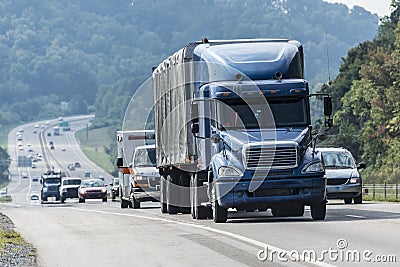 Blue Semi-Truck With Other Traffic On Interstate Highway Stock Photo