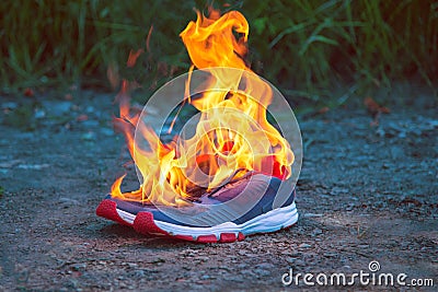 Blue shoes on the ground and on fire Stock Photo