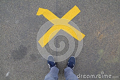 Blue shoes standing in front of a cross Stock Photo