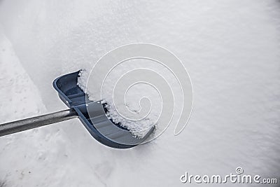 Blue shovel in the snow Stock Photo