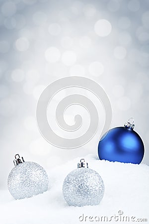 Blue and silver Christmas baubles on snow, silver background Stock Photo