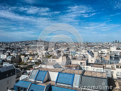 Blue skies and wispy clouds over the Paris rooftops; tiny Scre Coeur in distance Editorial Stock Photo