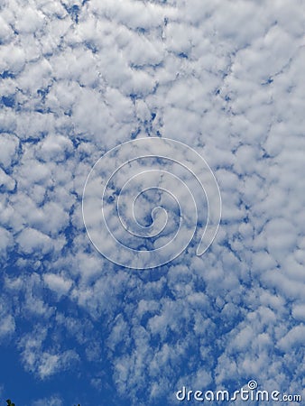 Blue sky background with clouds. Cirro-cumulus clouds on a blue sky on a sunny day. Cirrus sky. Spindrift clouds. Stock Photo