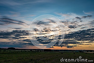 Blue sky background with evening fluffy curly rolling altocumulus altostratus clouds with setting sun. Good windy weather Stock Photo