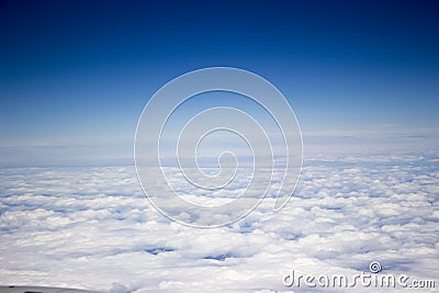 A view from the airplane, above white endless clouds, blue sky Stock Photo