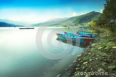 Blue Sky and calm Lake with colorful Boats Stock Photo