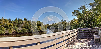Blue sky and clouds over a bridge that crosses Henderson Creek, which runs through Rookery Bay Stock Photo