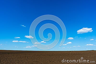 Blue sky with clouds and a plowed field Stock Photo
