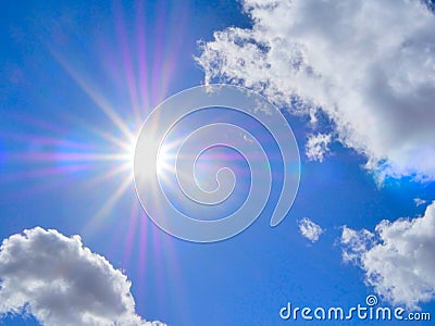 Blue sky with puffy white clouds and rays of light from sun. Stock Photo