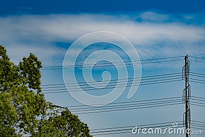 Blue sky on sunny day with high voltage electric power supply pole Stock Photo