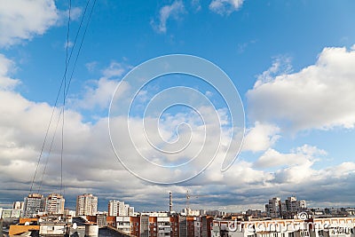 Blue sky with white clouds above roofs of apartment houses Stock Photo