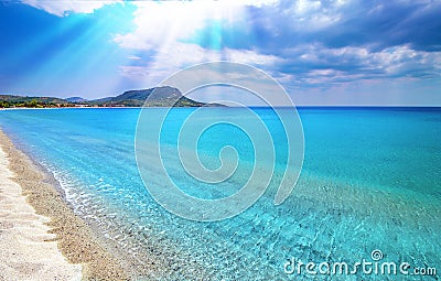 Blue sky, white clouds, sun rays, clear sea water background. Toroni beach, Sithonia, Greece Stock Photo