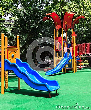 Blue Slides with Green Elastic Rubber Floor for Children, Playground Stock Photo