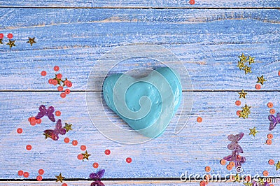 Blue slime clod in heart form on blue wooden background Stock Photo
