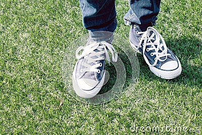 Blue sneakers on a kids feet outdoors Stock Photo