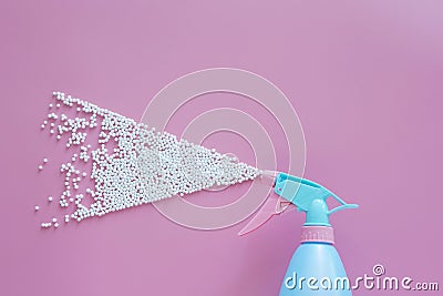 Blue spray bottle spraying white bubble foam on pink background with copy space. creative minimal for cleaning concept. Stock Photo