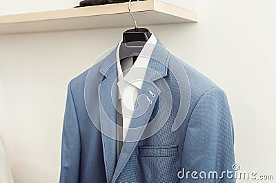 Blue suit jacket with a white shirt on the rack Stock Photo