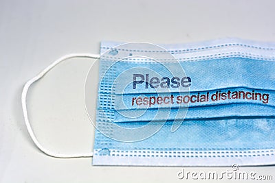 Blue surgical mask with the indication to maintain social distancing and not to stay so close. Covid-19 pandemic and social Stock Photo