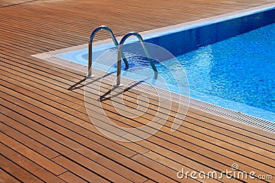 Blue swimming pool with teak wood flooring Stock Photo