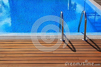 Blue swimming pool with teak wood flooring Stock Photo