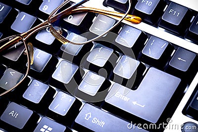 Blue toned keyboard with glasses Editorial Stock Photo