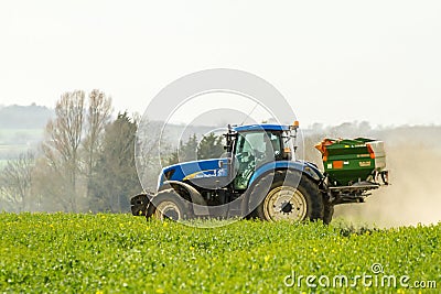 Blue Tractor and fertilizer spreader in field Editorial Stock Photo