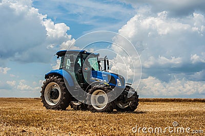 Blue tractor New Holland in motion at demonstration field site at agro exhibition Tractor working on the farm, modern agricultural Editorial Stock Photo