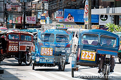 Blue Tricycles of Dumaguete driving on The Road Editorial Stock Photo