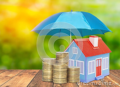 Umbrella protection House coins savings a business. Protection money insurance home concept Stock Photo