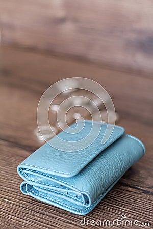 Blue wallet and coins on a wooden background Stock Photo