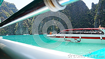 Blue water, green hills and steep rocks. The boat sails near the island. Boat with tourists in the Bay Editorial Stock Photo