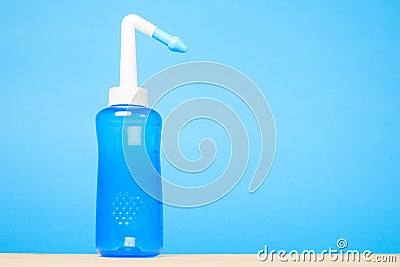 Blue water pulse nasal wash bottle on blue background, nasal irrigation concept Stock Photo