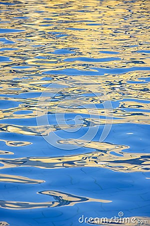 Blue water surface of pool with bizarre waves. Fantastic abstract reflections and glare on water. Close-up. Copy space. Stock Photo