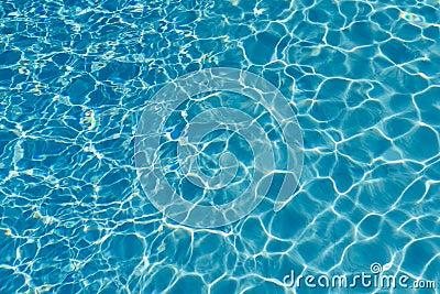 Blue water in swimming pool background. Ripple Water in swimming pool with sun reflection. Blue swimming pool rippled water detail Stock Photo