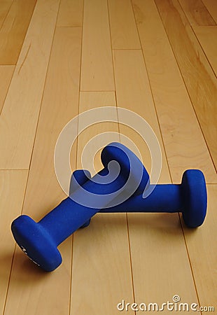 Blue Weights on Hardwood Floor of Fitness Center Stock Photo